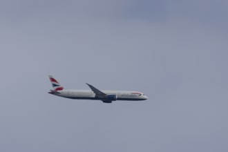 Boeing 787-9 Dreamliner jet passenger aircraft of British Airways airlines in flight in a blue sky,