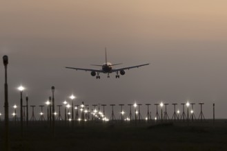 Airbus jet passenger aircraft in flight landing at sunset at London Stansted airport, Essex,
