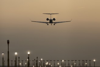 Bombardier Global business jet passenger aircraft in flight landing at sunset at London Stansted