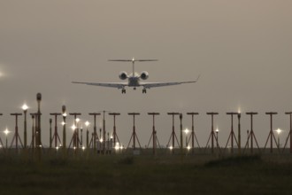 Bombardier Global business jet passenger aircraft in flight landing at sunset at London Stansted