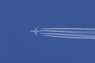 Airbus A340-300 jet aircraft of Lufthansa airlines in flight in a blue sky with vapour trails or