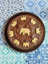 Round cake with elephant pattern made of chocolate dough on colourful cloth Lower Austria Austria