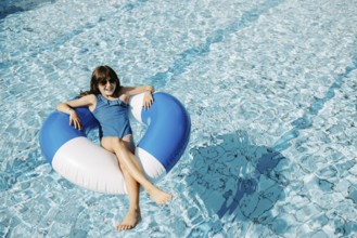 Girl, 10, swims in a swimming tyre in the pool