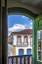 Windows, doors and the colonial architecture of the city of Ouro Preto through an old window, Ouro