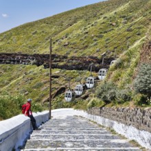 Hiker on stairs, old road to the harbour of the capital Fira, cable car, Thira, Santorini,
