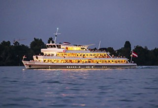 Brightly illuminated passenger ship VORARLBERG underway on Lake Constance during the blue hour.