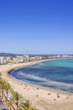 Aerial view at a sand beach at a resort by the mediterranean sea with people sunbathing on the