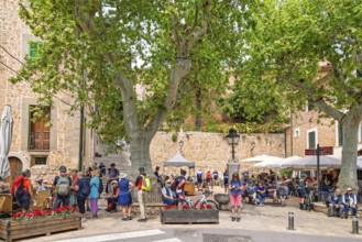 Many tourists in the square with outdoor restaurants in Fornalutx an old idyllic village in