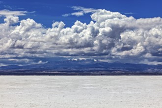 Scenic salt flat with dramatic clouds and distant mountain peaks on the horizon, The endless