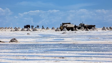 Vehicles and people move between salt hills on a shiny salt surface, The endless expanses of the