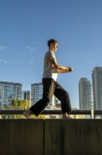 Vertical shot of a solo martial arts training on a sunny day in the city