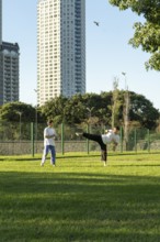 Young martial artists practicing Taekwondo outdoors at sunset