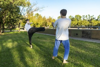 Young martial artists practicing Taekwondo outdoors