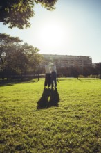 Young men silhouetted by bright sunlight after an outdoor martial arts training session