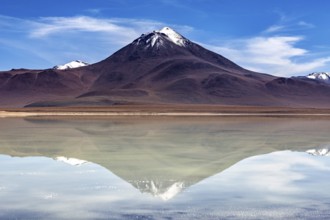 Majestic volcano reflected in a calm lake under a radiant sky, The Laguna Colorada in Bolivia