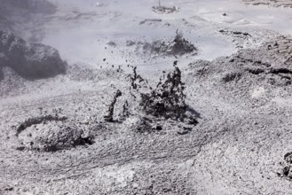 Bubbling mud erupts in a dark geothermal environment, The mud volcanoes and fumaroles on the