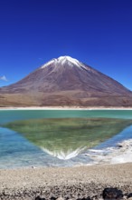 Striking volcano with a turquoise lake whose clear surface reflects the majestic mountain, The