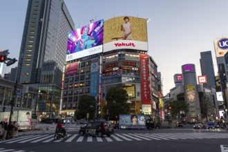 Cars in traffic at Shibuya Crossing, world-famous intersection in the Shibuya district, behind it