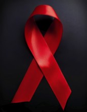 Close-up of a red awareness ribbon symbolizing support for causes like HIV/AIDS and heart disease,