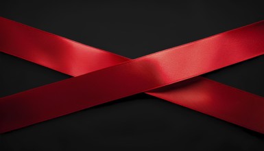 Two vibrant red satin ribbons crossed against a sleek black background, creating a minimalistic and