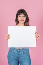 Smiling woman holding a blank sign with copy space for breast cancer awareness