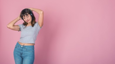 Happy woman listening to music on headphones with copy space