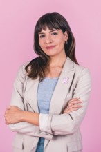 Positive woman with hands behind head and pink ribbon symbolizing breast cancer awareness
