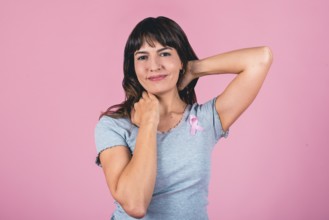 Smiling woman with pink ribbon raising awareness for breast cancer