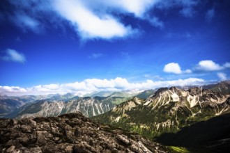 View of a mountain landscape with a wide sky and clouds. Kleinwalsertal Vorarlberg Austria