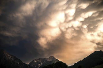 Dramatic cloud formations over a mountain massif in the evening light. Kleinwalsertal Vorarlberg