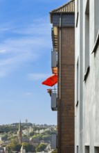Orange parasol on a balcony of an apartment block in Wuppertal, Germany, digitally reworked