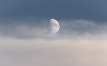 Half moon in a sea of clouds. Frankfurt am Main, Hesse, Germany