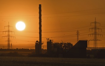 Sunrise behind an asphalt mixing plant. Niederursel, Frankfurt am Main, Hesse, Germany