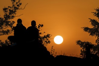 Silhouettes in front of the setting sun. Großer Feldberg in the Taunus, Hesse, Germany