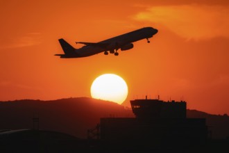 Aircraft takes off in the sunset. Frankfurt Airport, Hesse, Germany