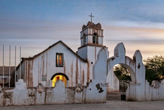 Illuminated church in the evening with warm light and ecclesiastical cross, The church of San Pedro