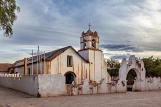 Rustic church under a cloudy sky, striking cross and historic architecture, The church of San Pedro
