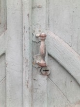 Fragment of a gray old wooden door with a handle