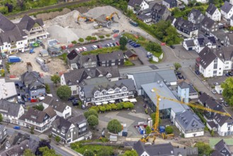 Aerial view, community centre and market square with shops, restaurant and sunshades and trees,