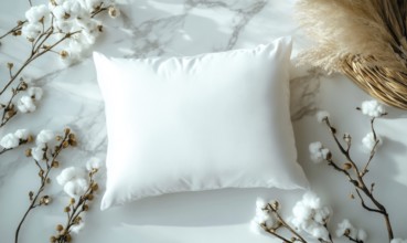 A white pillow on a marble surface framed by cotton branches with soft ambient lighting. AI