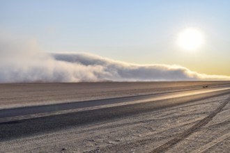 Abandoned area with dusty dirt road and some fog at evening time in Namibia