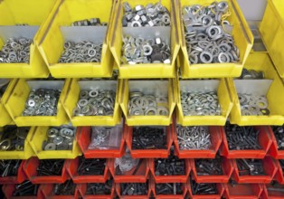 Full frame industrial background showing yellow and red boxes filled with lots of various screws