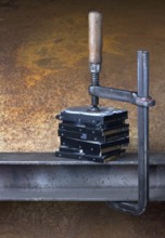 Some hard disk drives compressed with a screw clampin rusty back