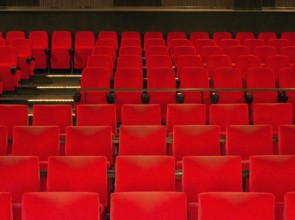 Indoor scenery showing a movie theater with red seats in warm ambiance
