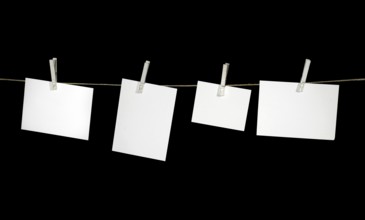 Clothesline with some white labels fixed with clothes pins in black back