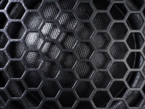 Full frame black grid of a speaker detail in dark back