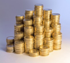 Lots of stacked 1 euro coins incolorful illuminated ambiance