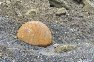 Rusty metal ball used for stone crushing in stony back