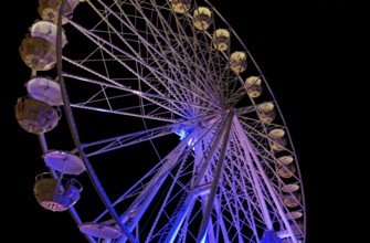 Colorful illuminated ferris wheel detail at night