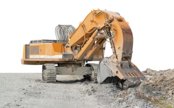 Huge orange colored tracked excavator partly isolated on stony ground